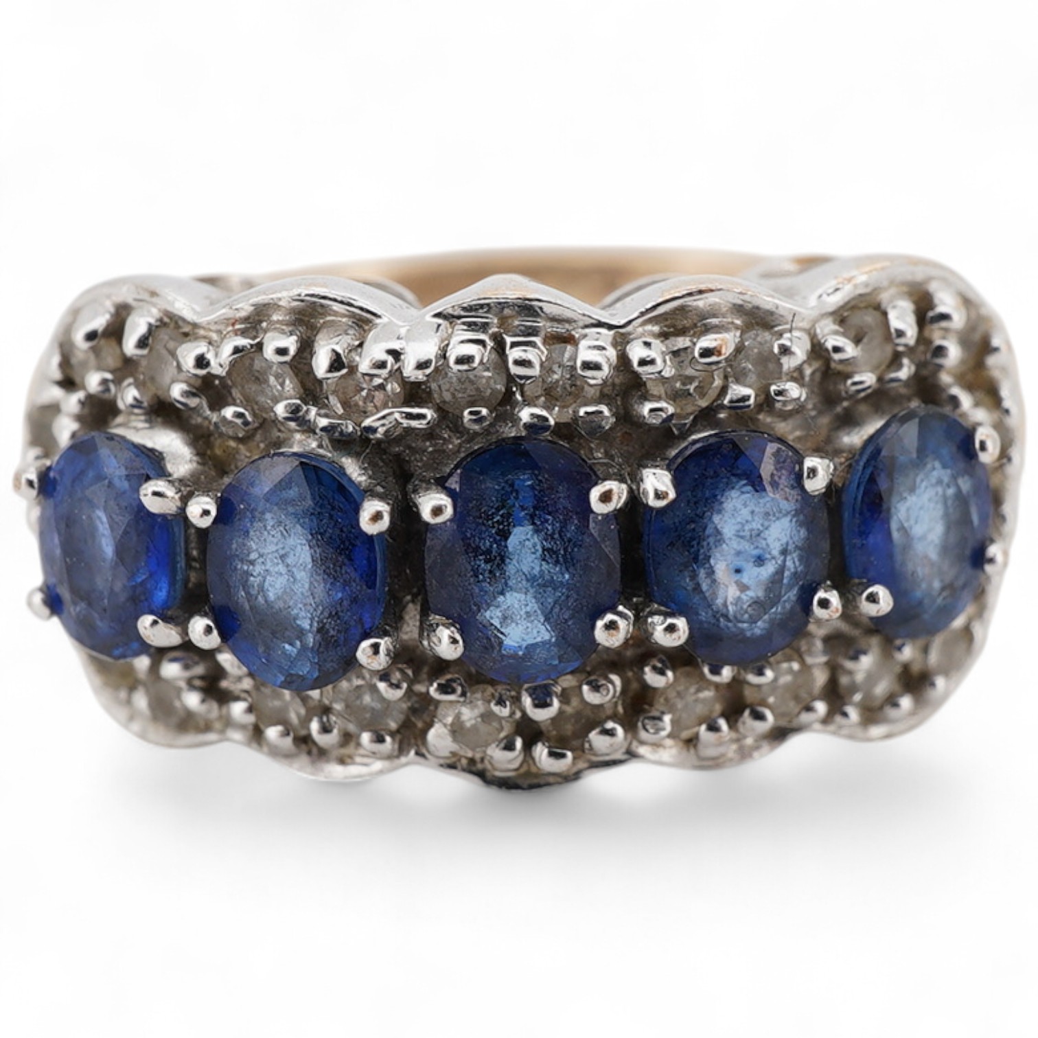 A 9ct gold and five stone oval cut sapphire set half hoop ring, with a diamond chip set border, size N, gross weight 3.9 grams.